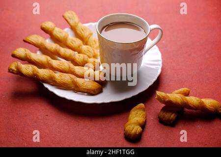 Indische khari oder Karee oder salzige Puffy braune Snacks, serviert mit indischem heißen Tee, indisches Frühstück. Stockfoto