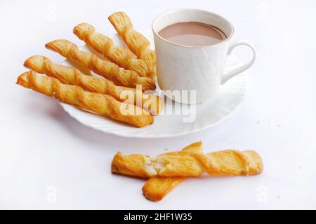 Indische khari oder Karee oder salzige Puffy braune Snacks, serviert mit indischem heißen Tee, indisches Frühstück. Stockfoto