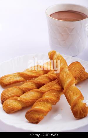 Indische khari oder Karee oder salzige Puffy braune Snacks, serviert mit indischem heißen Tee, indisches Frühstück. Stockfoto