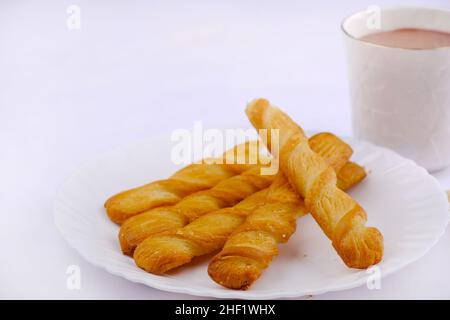 Indische khari oder Karee oder salzige Puffy braune Snacks, serviert mit indischem heißen Tee, indisches Frühstück. Stockfoto