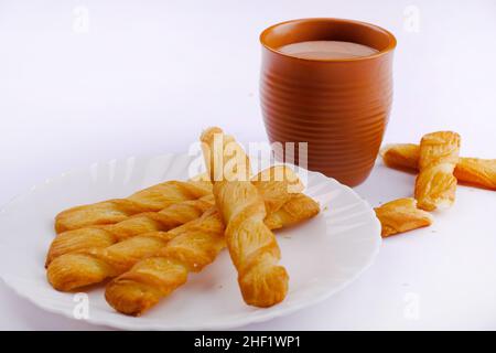 Indische khari oder Karee oder salzige Puffy braune Snacks, serviert mit indischem heißen Tee, indisches Frühstück. Stockfoto