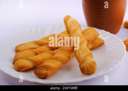 Indische khari oder Karee oder salzige Puffy braune Snacks, serviert mit indischem heißen Tee, indisches Frühstück. Stockfoto