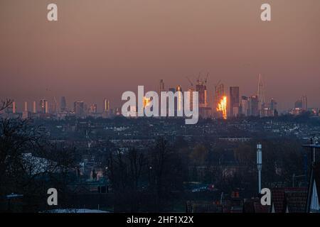 WIMBLEDON, LONDON, GROSSBRITANNIEN. 13. Januar 2022. Die Skyline von London und die Gebäude des Finanzdistrikts bei Sonnenuntergang in goldenem Abendlicht. Kredit: amer ghazzal/Alamy Live Nachrichten Stockfoto