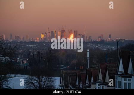 WIMBLEDON, LONDON, GROSSBRITANNIEN. 13. Januar 2022. Die Skyline von London und die Gebäude des Finanzdistrikts bei Sonnenuntergang in goldenem Abendlicht. Kredit: amer ghazzal/Alamy Live Nachrichten Stockfoto