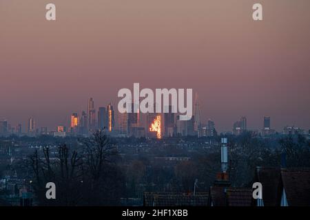 WIMBLEDON, LONDON, GROSSBRITANNIEN. 13. Januar 2022. Die Skyline von London und die Gebäude des Finanzdistrikts bei Sonnenuntergang in goldenem Abendlicht. Kredit: amer ghazzal/Alamy Live Nachrichten Stockfoto