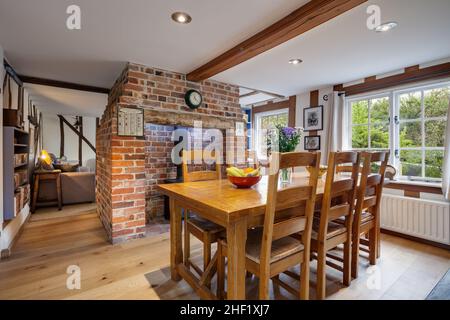 Clare, Suffolk - 27 April 2018: Schönes, charmantes, kleines traditionelles Cottage Esszimmer mit freiliegendem Backsteinkamin und Holzboden Stockfoto