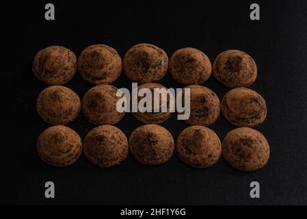 Schokoladentrüffel auf schwarzem Hintergrund. Schokolade Süßigkeiten. Stockfoto