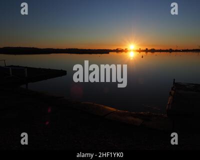 Sheerness, Kent, Großbritannien. 13th Januar 2022. UK Wetter: Sonnenuntergang am Barton's Point See in Sheerness, Kent. Kredit: James Bell/Alamy Live Nachrichten Stockfoto