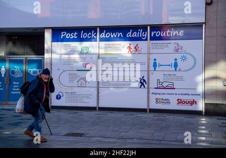 Slough, berkshire, Großbritannien. 13th. Januar 2022. Ein Mann geht an Post Covid-19 vorbei, die täglich routinemäßige Banner in der Slough High Street einsperren. Quelle: Maureen McLean/Alamy Stockfoto