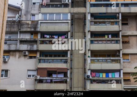 PODGORICA, MONTENEGRO - 4. JUNI 2019: Menschen auf dem Balkon eines Mehrfamilienhauses in Podgorica, der Hauptstadt Montenegros Stockfoto