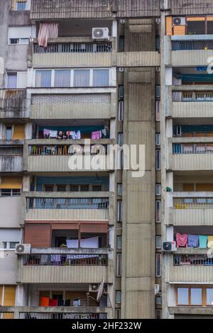 PODGORICA, MONTENEGRO - 4. JUNI 2019: Menschen auf dem Balkon eines Mehrfamilienhauses in Podgorica, der Hauptstadt Montenegros Stockfoto