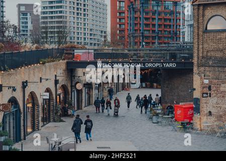 London, Großbritannien - 01. Januar 2022: Blick aus der Höhe auf Menschen, die unter dem Willkommensschild in Coal Drops Yard, einem Einkaufsziel und Hotspot für Feinschmecker, spazieren gehen Stockfoto