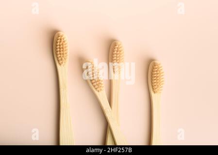 Vier umweltfreundliche natürliche Bambus-Zahnbürsten auf rosa Hintergrund. Stockfoto