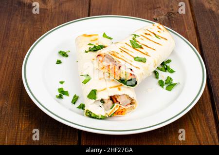 Dünne Lavasch mit Gemüse und Huhn auf dem Teller, Shawarma. Foto Stockfoto