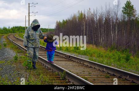 Großmutter und Enkelin laufen auf den Schienen. Chanty-Mansiysk Bezirk Stockfoto