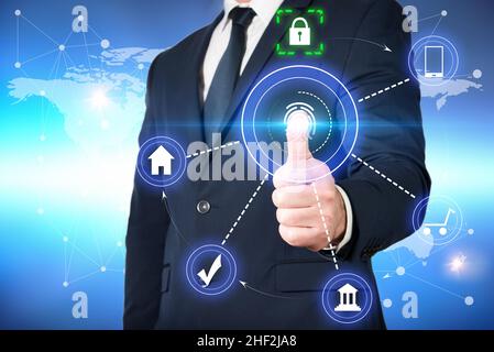 Mann in der Jacke scannt seinen Fingerabdruck, um auf seine Bankkonten zuzugreifen und mit absoluter Sicherheit Einkäufe tätigen zu können. Online-Sicherheit Stockfoto