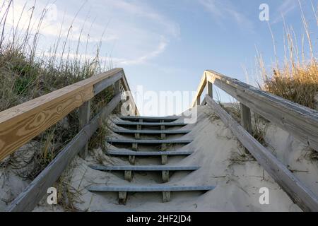 Eine Promenade über riesige Sanddünen bietet Zugang zu den ruhigen südlichen Stränden auf Jekyll Island, Georgia, einem beliebten Ziel für langsame Reisen. Stockfoto