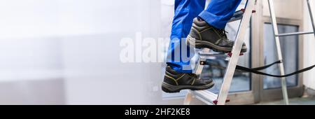 Mann Kletternde Trittleiter In Sicherheitsschuhen Stockfoto