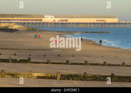 Spaziergang am Strand von Frinton on Sea, Essex mit Blick auf den Walton Pier Stockfoto