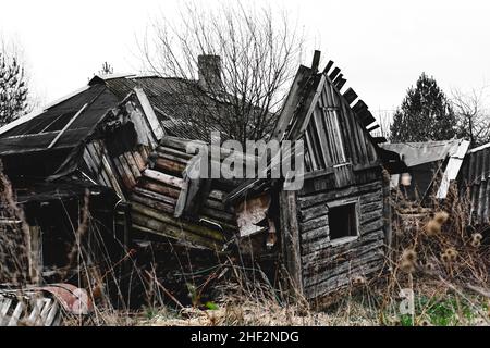 Altes zerstörtes verlassenes Holzhaus. Rustikales kaputtes Gebäude. Ruinen. Stockfoto