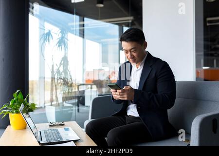 Chinesischer Geschäftsmann, der in einem Online-Shop im Büro einkaufen arbeitet Stockfoto