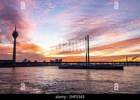 Winteruntergang auf dem Rhein bei DŸsseldorf, Häuser im Medienhafen, Frachtschiff, Rheinkniebrücke, NRW, Deutschland Stockfoto