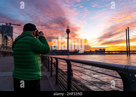 Winteruntergang auf dem Rhein bei DŸsseldorf, Häuser im Medienhafen, Frachtschiff, Rheinkniebrücke, NRW, Deutschland Stockfoto