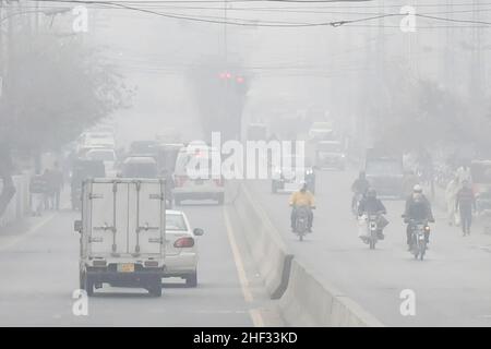 Lahore, Pakistan. 13th Januar 2022. Fahrzeuge fahren am 13. Januar 2022 im dichten Nebel in Lahore, Pakistan, auf einer Straße. Quelle: Sajjad/Xinhua/Alamy Live News Stockfoto