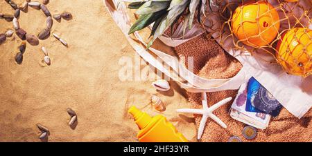Konzept des Sandstrandes, Draufsicht, Banner mit Zeichnung auf dem Sand in Form einer Sonne aus Muscheln. Sandhintergrund mit Kopierplatz für tex Stockfoto