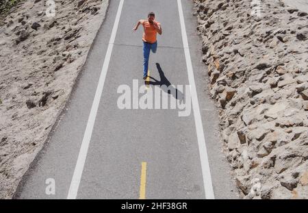 Mann, der auf der Straße läuft. Sportlicher Mann Läufer laufen im Sommer. Stockfoto