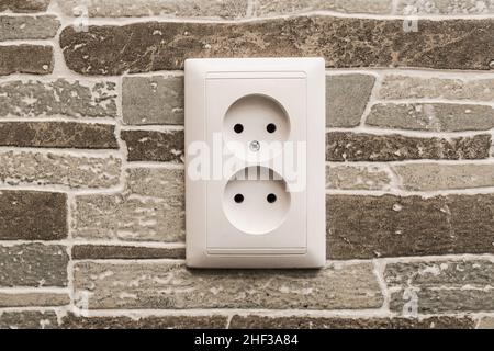 Duale Steckdose für den Anschluss von elektrischen Geräten zu Hause an der Wand. Stockfoto