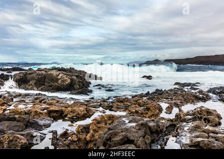 Sonnenuntergang mit dramatischen Himmel an der felsigen Küste in Tenesar, Lanzarote Stockfoto