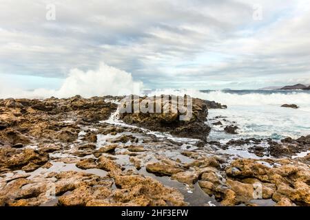 Sonnenuntergang mit dramatischen Himmel an der felsigen Küste in Tenesar, Lanzarote Stockfoto