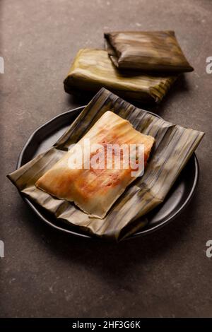 Prähispanische Gericht typisch für Mexiko und einige lateinamerikanische Länder. Maisteig in Bananenblätter gewickelt. Die Tamales werden gedämpft. Stockfoto