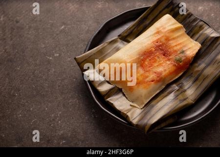 Prähispanische Gericht typisch für Mexiko und einige lateinamerikanische Länder. Maisteig in Bananenblätter gewickelt. Die Tamales werden gedämpft. Stockfoto