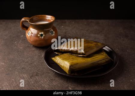 Prähispanische Gericht typisch für Mexiko und einige lateinamerikanische Länder. Maisteig in Bananenblätter gewickelt. Die Tamales werden gedämpft. Stockfoto