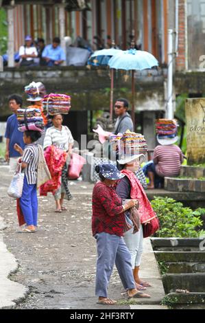 Frauen, die Sarongs verkaufen, die auf ihren Köpfen gebündelt sind, werden in Tegalallang in Ubud, Bali, Indonesien, verkauft Stockfoto