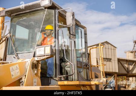 Manueller Arbeiter, der den Laster im Werk fährt Stockfoto