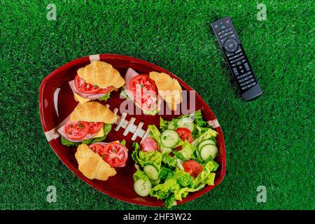 Vorspeisen auf dem Teller mit tv-Fernbedienung für die Fußballparty. Draufsicht. Stockfoto