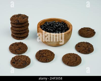 Sammlung von Chocolate Chip Cookies und Chip Schokolade in einer Holzschale auf weißem Hintergrund. Stockfoto