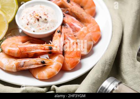 Platte mit leckeren Garnelen mit Sauce auf dem Tisch, Nahaufnahme Stockfoto