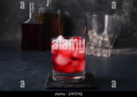 Ein Glas leckerer Manhattan-Cocktail auf schwarzem Hintergrund Stockfoto