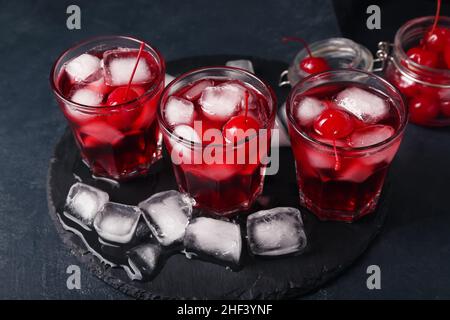 Gläser mit leckeren Manhattan-Cocktails auf schwarzem Hintergrund Stockfoto