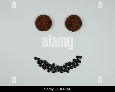 Kreatives Foto von Chocolate Chip Cookies, die ein lächelndes Gesicht bilden. Stockfoto