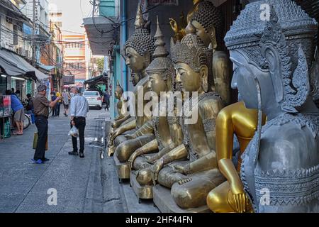 Eine Reihe verschiedener Buddha-Statuen befindet sich vor einem Geschäft für buddhistische Ritualobjekte in der Bamrung Muang Road, Bangkok, Thailand Stockfoto