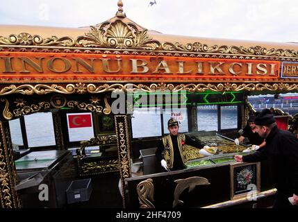 Makrelenfisch, gegrillt für die berühmten Fisch-Sandwiches, serviert von bunten Booten an der Galata-Brücke in Istanbul, Türkei. Stockfoto