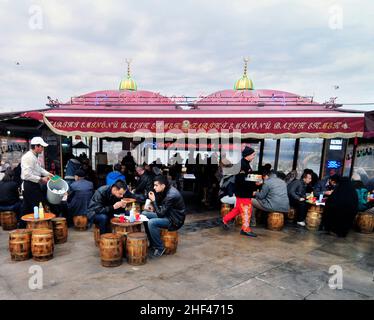 Makrelenfisch, gegrillt für die berühmten Fisch-Sandwiches, serviert von bunten Booten an der Galata-Brücke in Istanbul, Türkei. Stockfoto