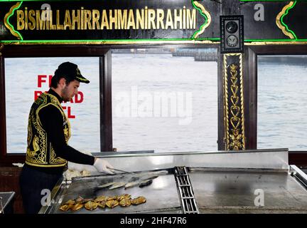Makrelenfisch, gegrillt für die berühmten Fisch-Sandwiches, serviert von bunten Booten an der Galata-Brücke in Istanbul, Türkei. Stockfoto