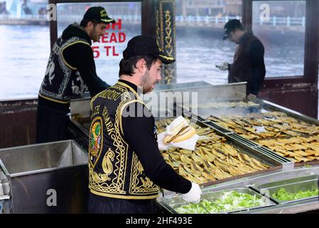 Makrelenfisch, gegrillt für die berühmten Fisch-Sandwiches, serviert von bunten Booten an der Galata-Brücke in Istanbul, Türkei. Stockfoto
