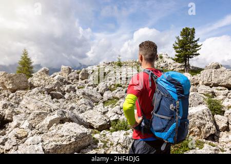 Wanderer mit einem Rucksack, der in einem Felde aus Felsen steht Stockfoto